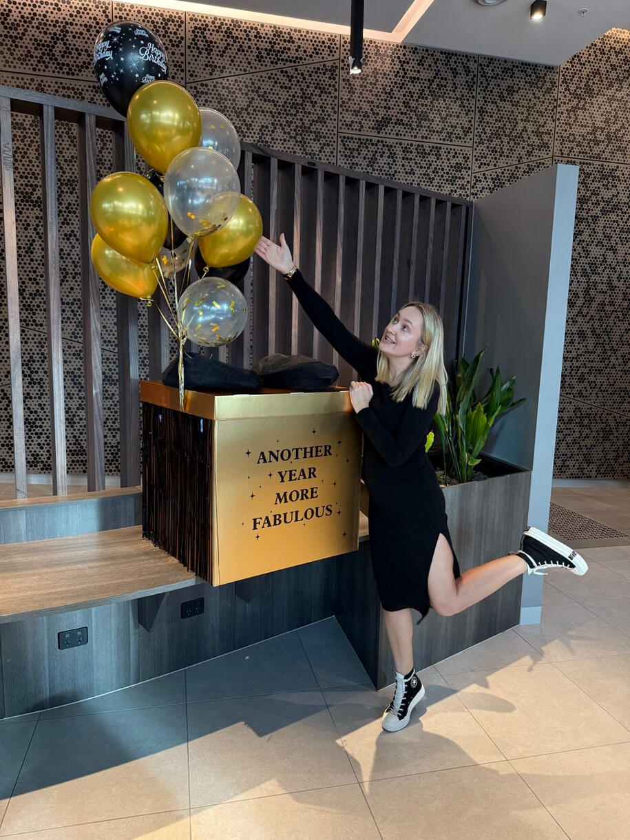 Black balloon gift box with golden balloons and a birthday design